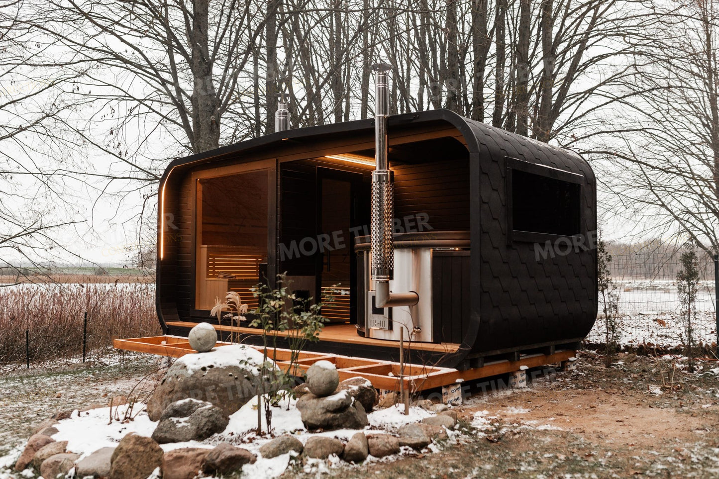 teaming hot tub beside glowing sauna at sunset