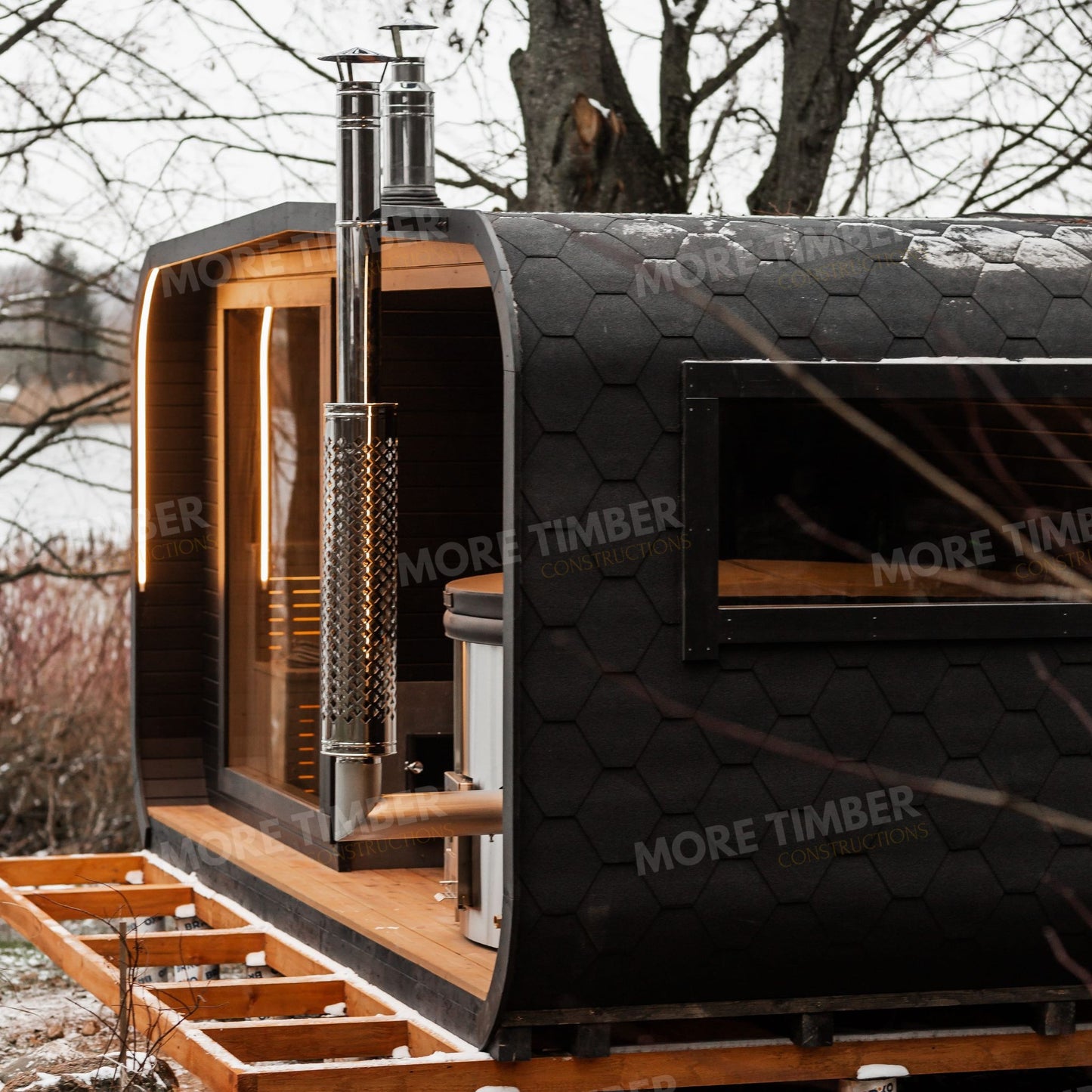 Lakeside sauna with wooden hot tub and view of water