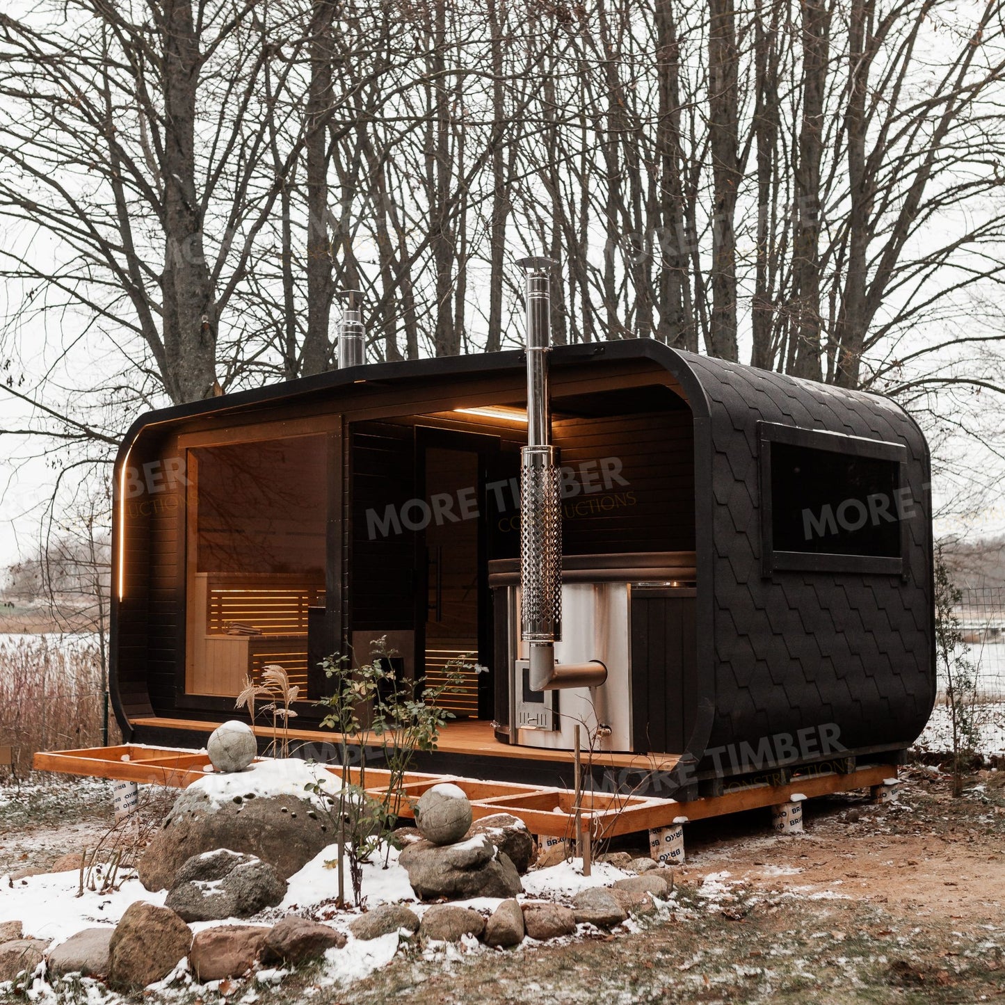 Log cabin sauna with steaming hot tub in winter snow