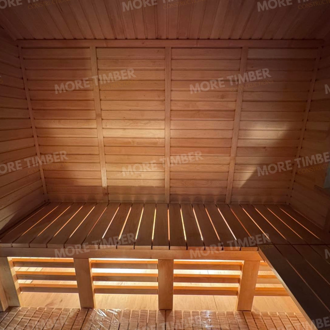 Wooden sauna with 'More Timber' branding, featuring wooden benches and a door.