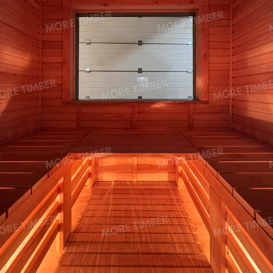 Wooden sauna with 'More Timber' branding, featuring wooden benches and a door.