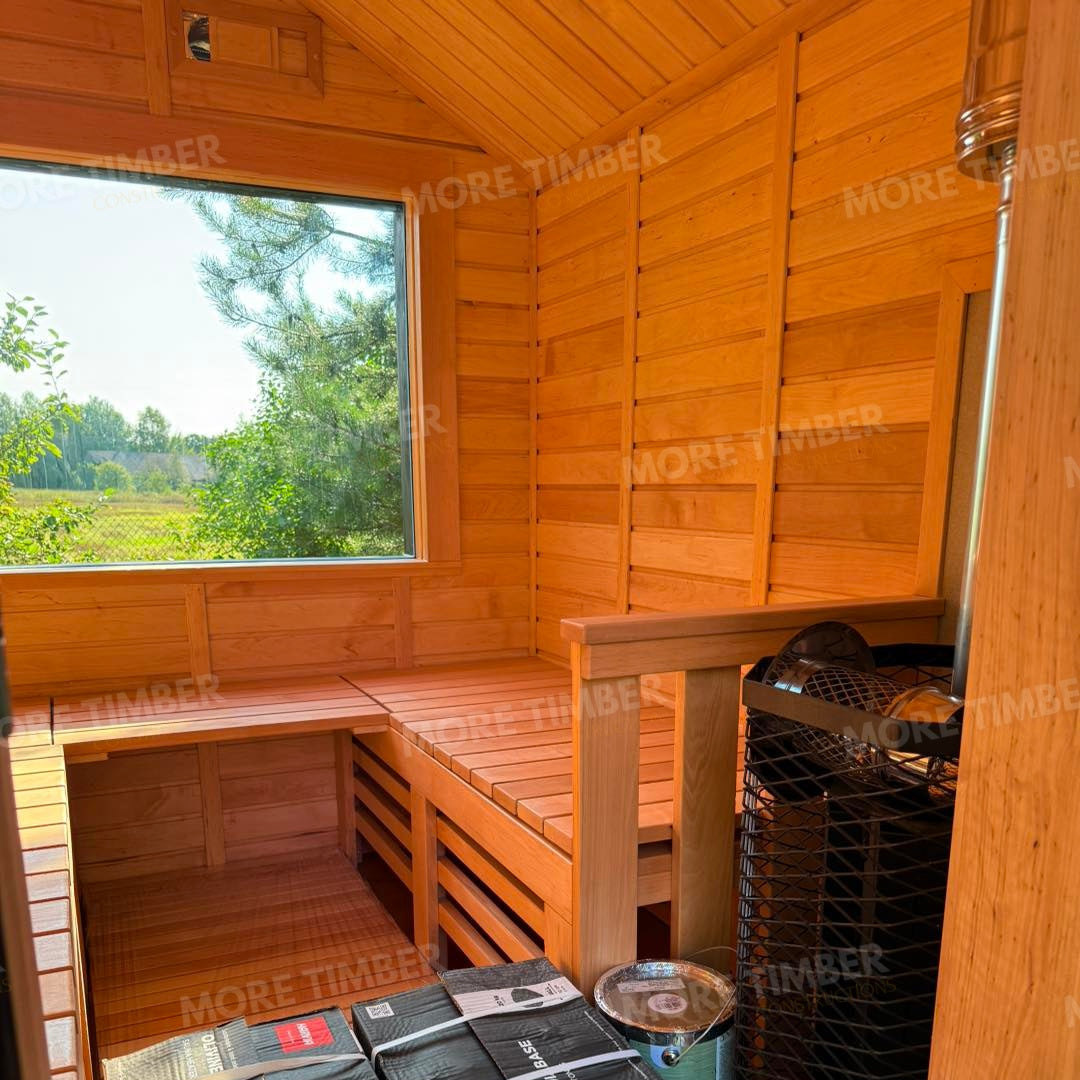 Wooden sauna with 'More Timber' branding, featuring wooden benches and a door.