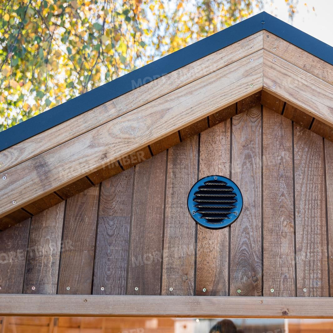 Wooden sauna with 'More Timber' branding, featuring wooden benches and a door.