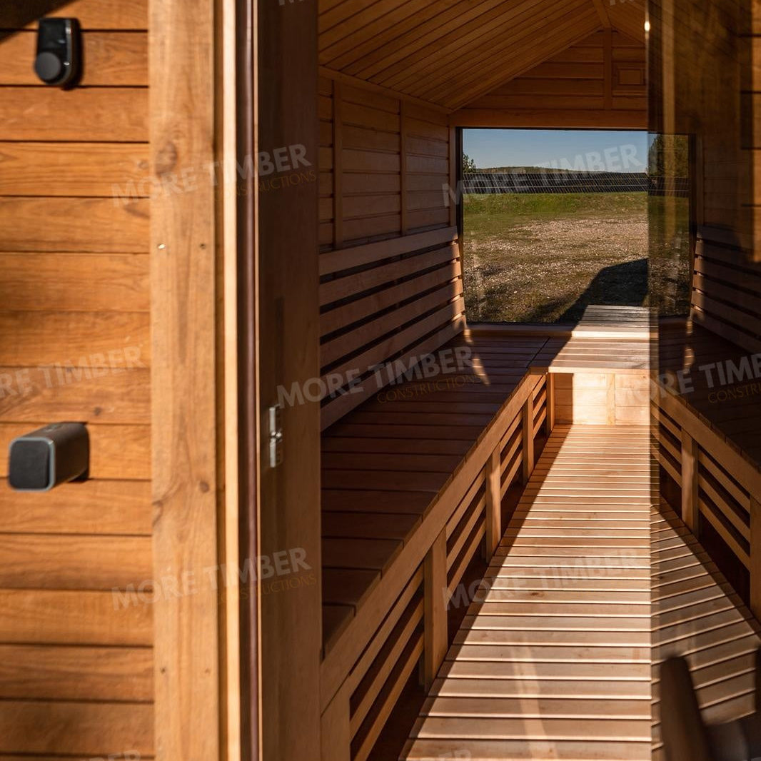 Wooden sauna with 'More Timber' branding, featuring wooden benches and a door.
