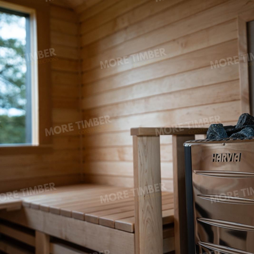 Wooden sauna with 'More Timber' branding, featuring wooden benches and a door.
