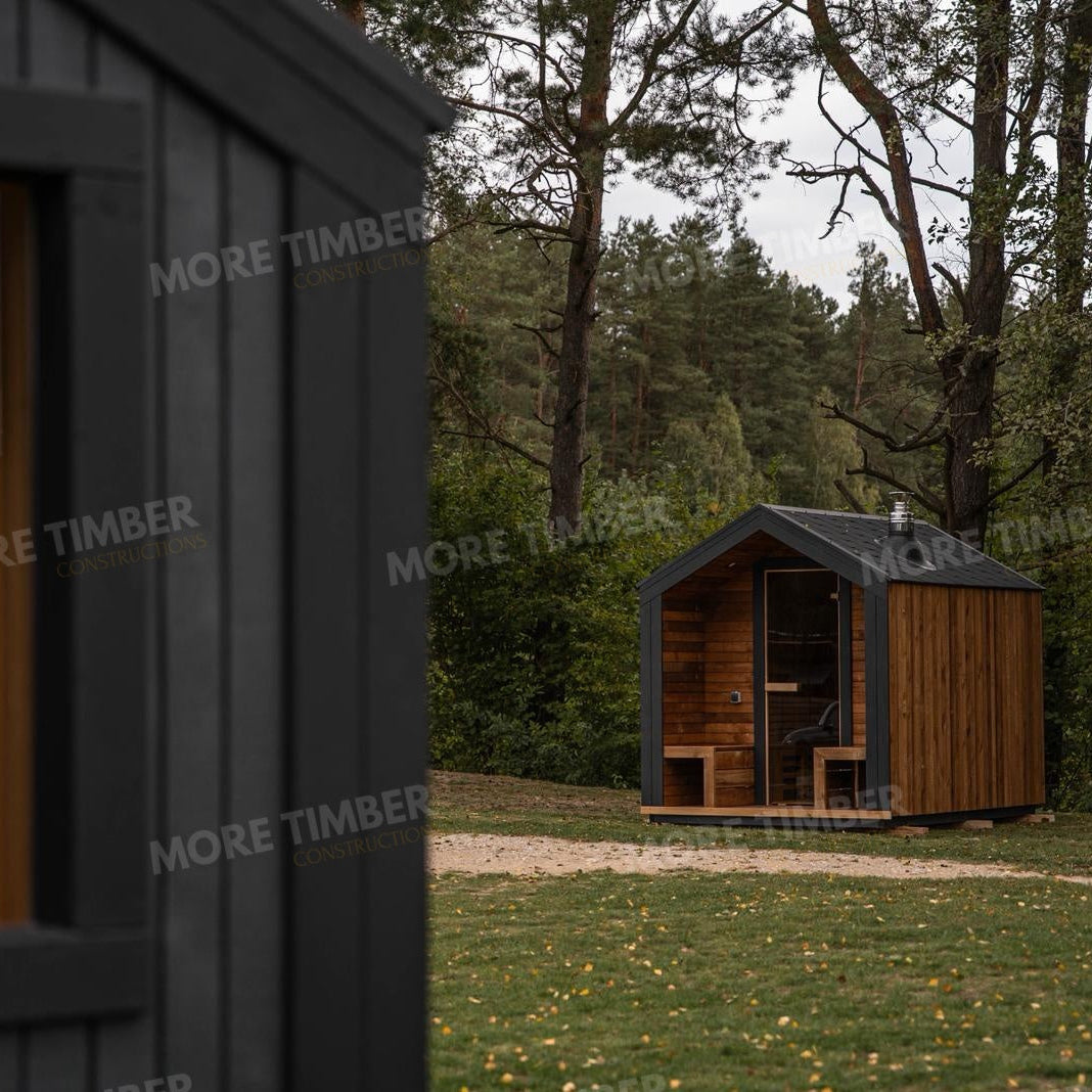 Wooden sauna with 'More Timber' branding, featuring wooden benches and a door.