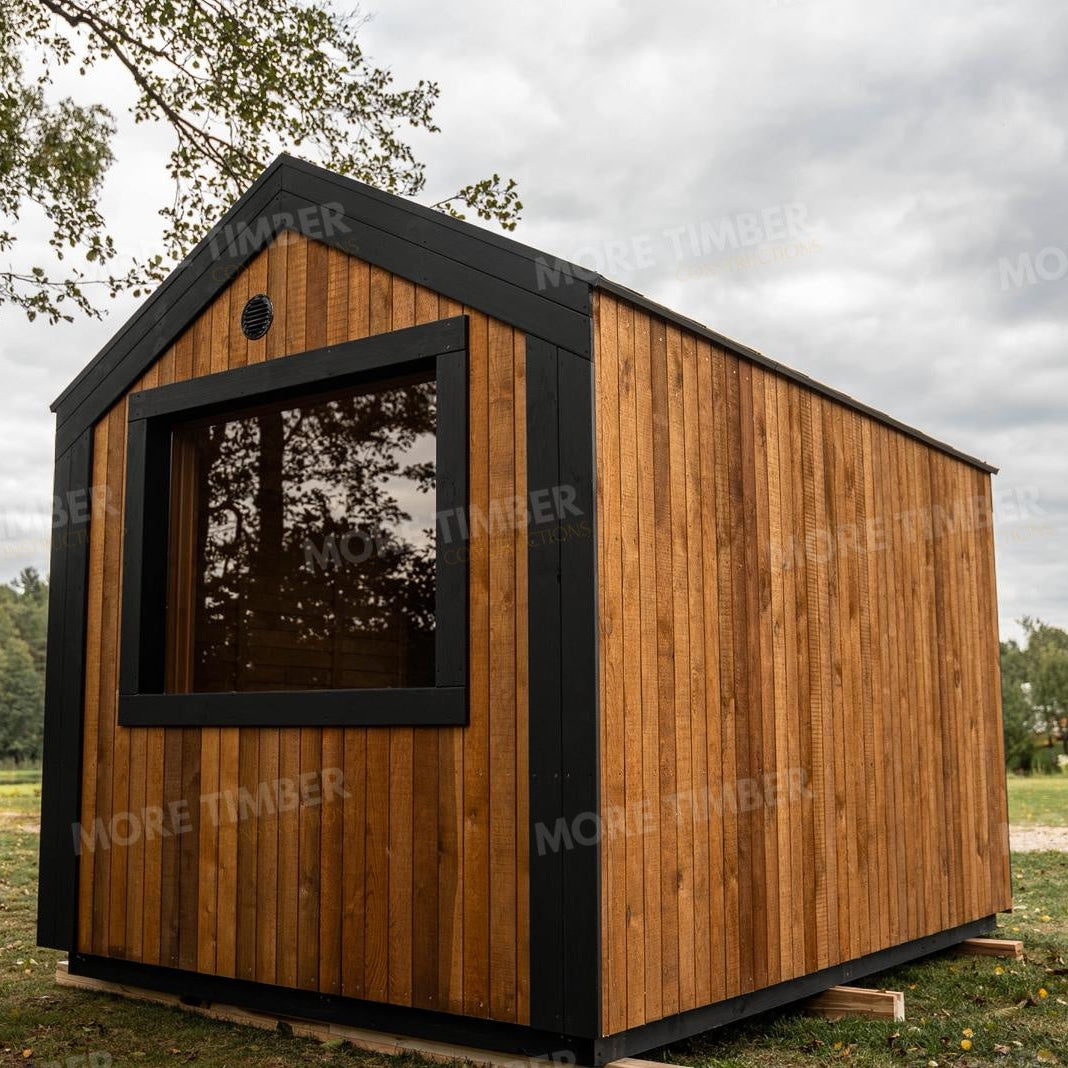 Wooden sauna with 'More Timber' branding, featuring wooden benches and a door.