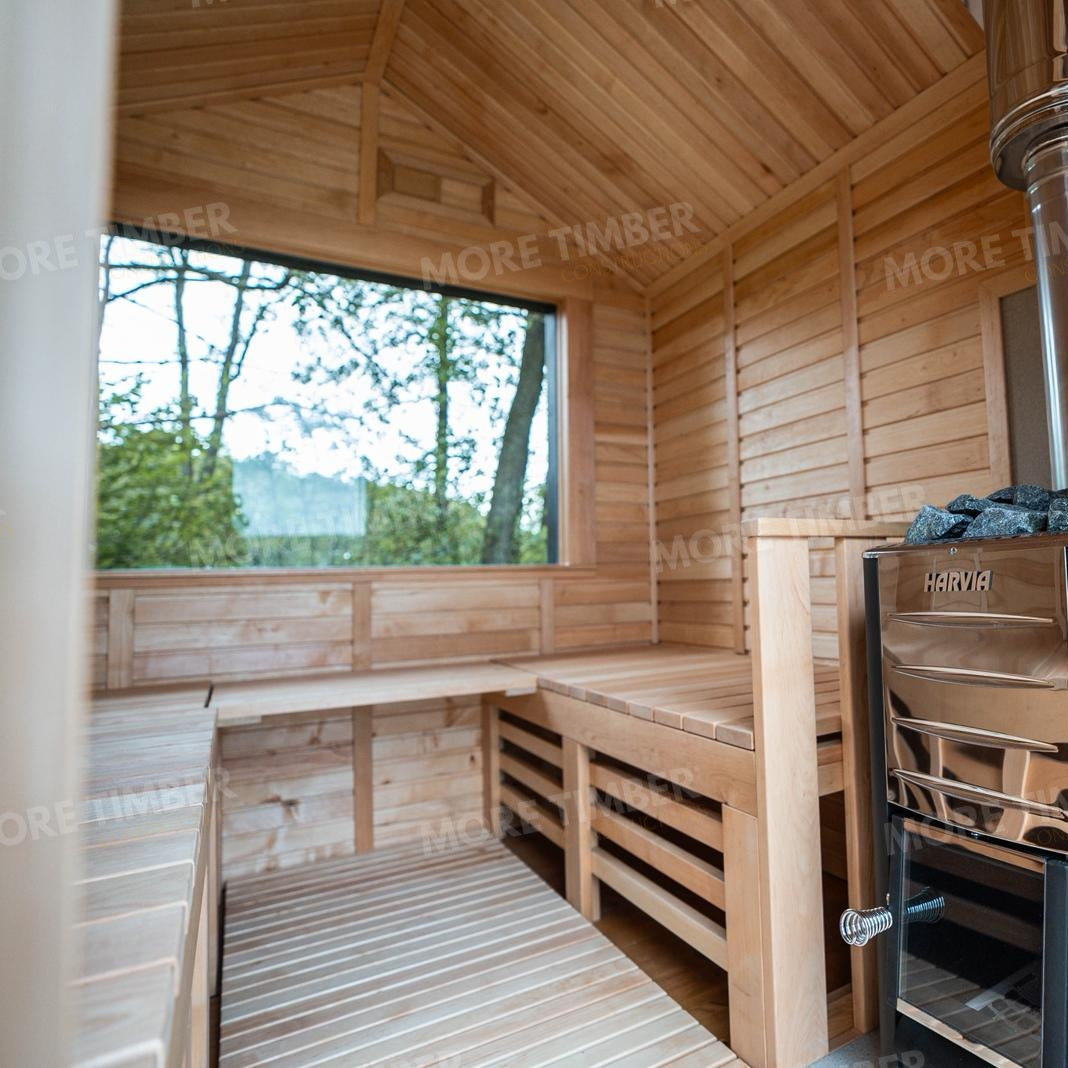 Wooden sauna with 'More Timber' branding, featuring wooden benches and a door.