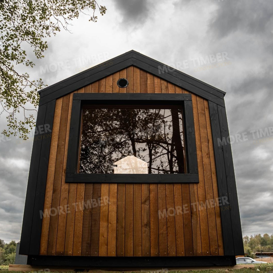 Wooden sauna with 'More Timber' branding, featuring wooden benches and a door.